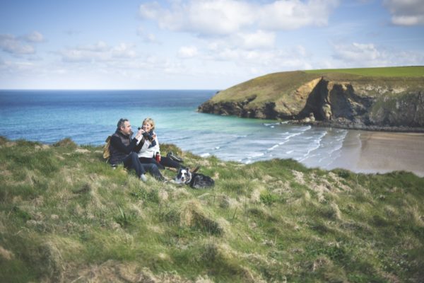 Couple sitting with their dog overlooking the beach